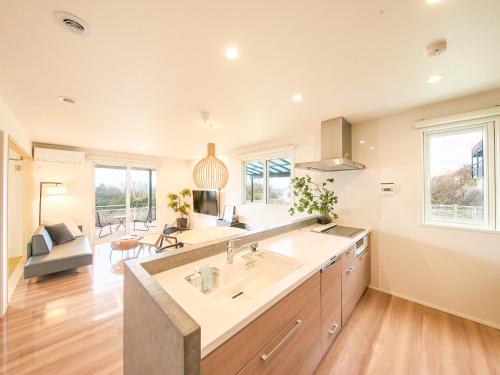 a kitchen with a large sink and a living room at HUG me Ocean awaji in Sumoto
