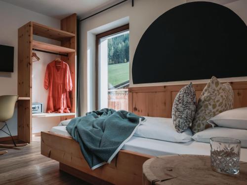 a bedroom with a bed with a large window at Hotel Schönberg in Rio Bianco