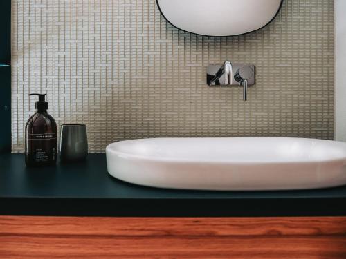 a white sink on a black counter in a bathroom at Hotel Schönberg in Rio Bianco