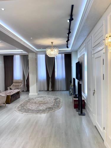 a living room with a chandelier and a room with a couch at Boulevard in Samarkand