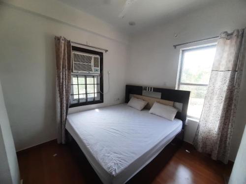 a bed in a room with a large window at Hotel Aditya Bikaner in Deshnoke