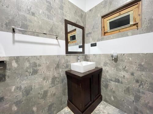 a bathroom with a sink and a mirror at Yala Cherish Inn & Safari in Tissamaharama
