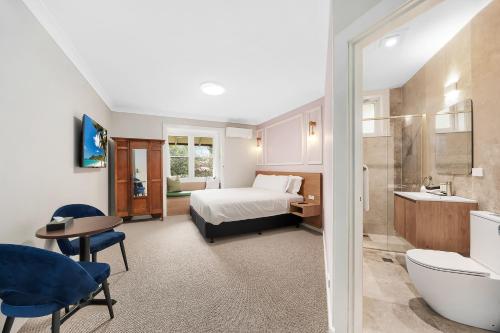 a hotel room with a bed and a bathroom at Hotel Avonleigh in Katoomba