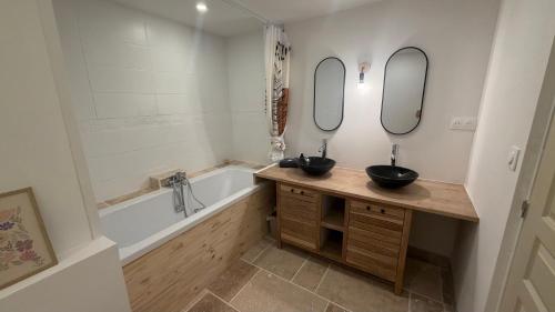 two sinks in a bathroom with a tub and a bathtubermott at Au Soleil Couchant in Wimille