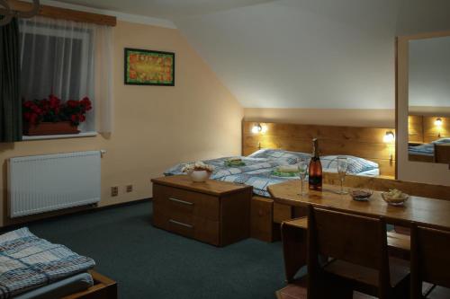 a bedroom with a bed and a table with a bottle of wine at Wellness Penzion Palice in Jindrichuv Hradec