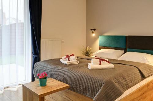 a bedroom with a large bed with towels on it at Apartamenty Marina Jastarnia Bis in Jastarnia