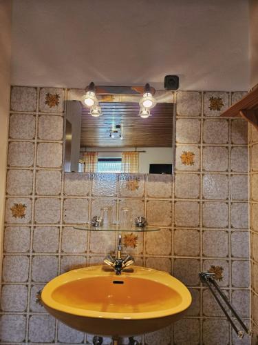 a bathroom with a yellow sink and a mirror at Pension Haus Donaublick in Deggendorf