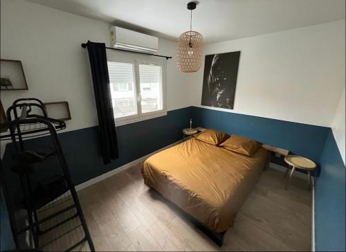 a bedroom with a bed with a blue accent wall at Au Soleil Couchant in Wimille