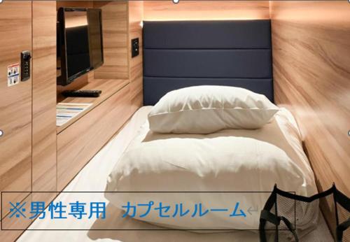 a bedroom with a bed and a tv at HOTEL LiVEMAX SAPPORO NAKAJIMA PARK GRANDE in Sapporo