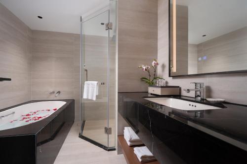 a bathroom with a tub and a sink and a shower at Liuhua Hotel in Guangzhou