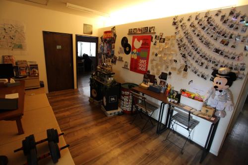 a room with a wall with many items on it at Bonfire Hostel Osaka in Osaka