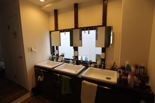 a bathroom with two sinks and a large mirror at Bonfire Hostel Osaka in Osaka