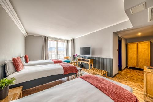 a hotel room with two beds and a television at Hotel Studio in Veliko Tŭrnovo