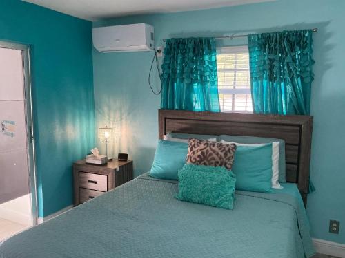 a blue bedroom with a bed with blue walls at Jubilee Gardens Freeport in Freeport