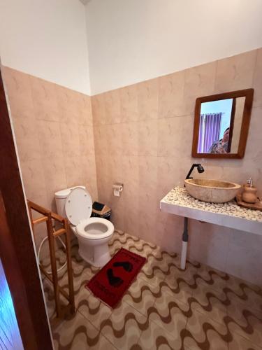 a bathroom with a sink and a toilet and a mirror at Kayana Lake View in Kubupenlokan