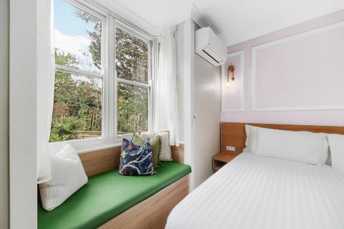 a bedroom with a bed and a window at Hotel Avonleigh in Katoomba