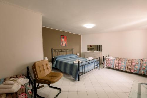 a bedroom with two beds and a chair in it at Pollutrendy in Pollutri