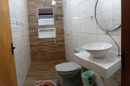a bathroom with a sink and a toilet and a mirror at Recanto do sol in Brotas