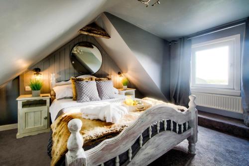a bedroom with a large bed with a large mirror at Portamaggie Cottage in Portpatrick