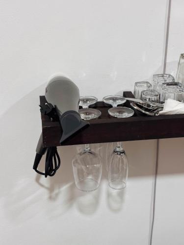 a table with glasses and a mixer on a shelf at Dimora Hideout in Homagama