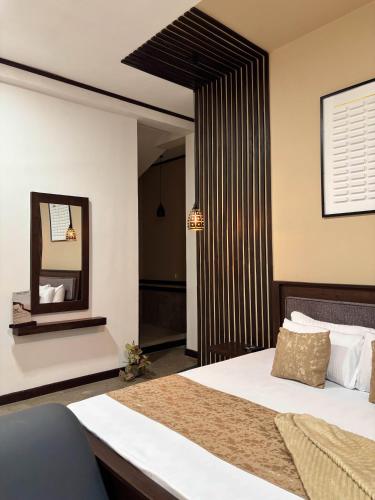 a bedroom with a large bed and a mirror at Dimora Hideout in Homagama