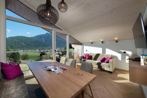 a living room with a wooden table and purple pillows at Harmls Aparthotel in Flachau