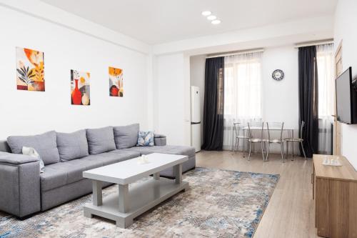 a living room with a couch and a table at Bright 2BR Residence Central Yerevan in Yerevan