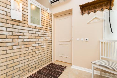 a hallway with a brick wall and a white door at Lossiplatsi Apartment in Haapsalu