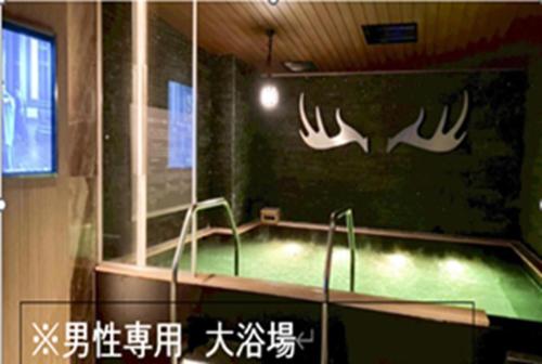 a room with a pool with antlers on the wall at HOTEL LiVEMAX SAPPORO NAKAJIMA PARK GRANDE in Sapporo