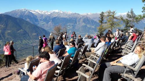 a crowd of people sitting in chairs on a mountain at Schötzerhof in Meltina