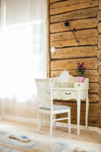 a white desk with a chair next to a wooden wall at Lossiplatsi Apartment in Haapsalu