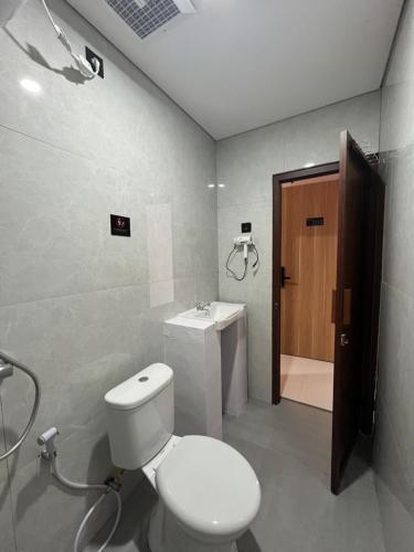 a bathroom with a white toilet and a sink at Pangeran Residence 2 in Adi Sutjipto