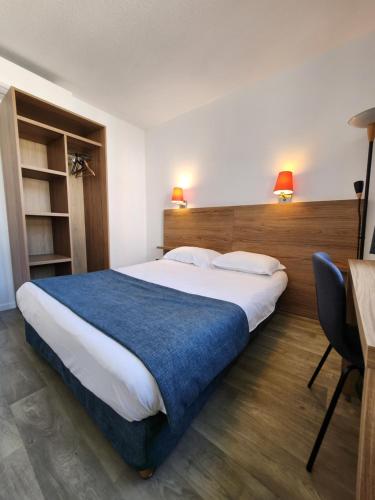 a bedroom with a large bed and a desk at Hôtel Alizé in Cannes