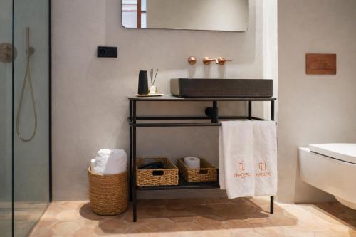 ein Badezimmer mit einem Regal für Handtücher und einem Waschbecken in der Unterkunft Tradere Hotel Boutique in Moncada