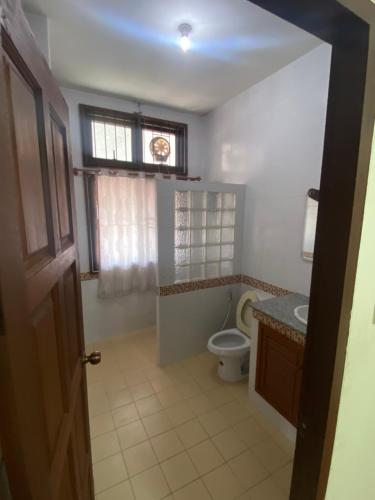 a bathroom with a toilet and a sink and a window at Wandeehomehost in Chiang Mai