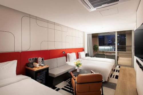 a hotel room with two beds and a couch at Hotel PJ Myeongdong in Seoul