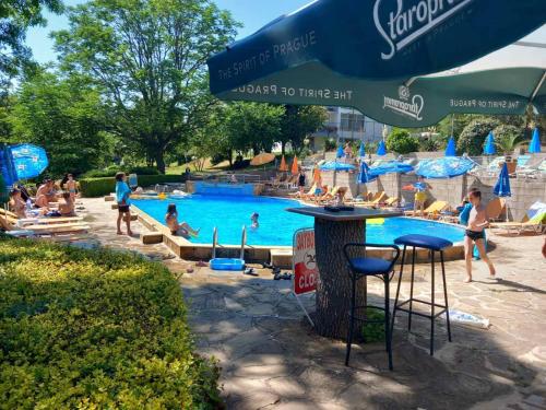 a group of people sitting around a swimming pool at Neptune Hotel in Saints Constantine and Helena