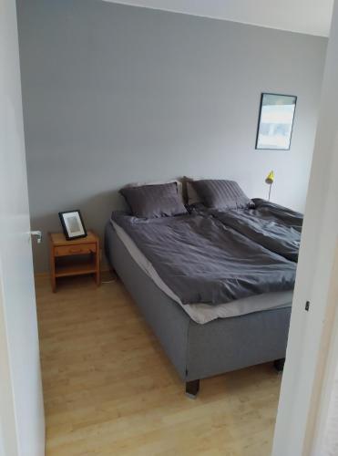 a bedroom with a bed and a table with a picture at Lägenhet Sandåsvägen in Mariehamn