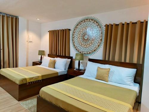 a bedroom with two beds and a picture on the wall at OHANA Homestay in Coron