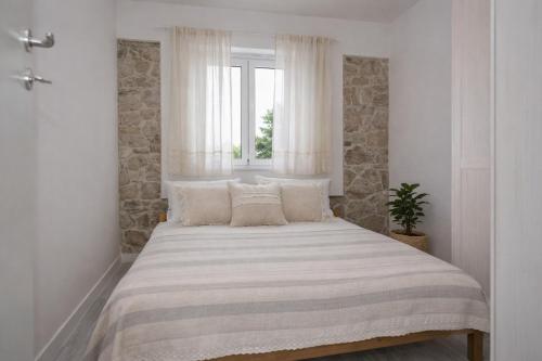 a bedroom with a large bed with a window at Didovi dvori in Bibinje