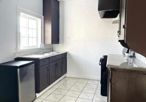 a kitchen with black cabinets and a window at Vernon Homes for the Soul in Los Angeles