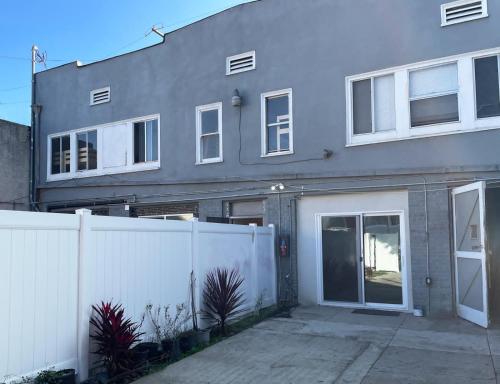 a house with a white fence in front of it at Vernon Homes for the Soul in Los Angeles