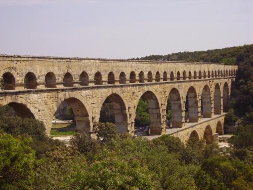 an old stone bridge with arches on a hill at La Cèzenole in Méjannes-le-Clap