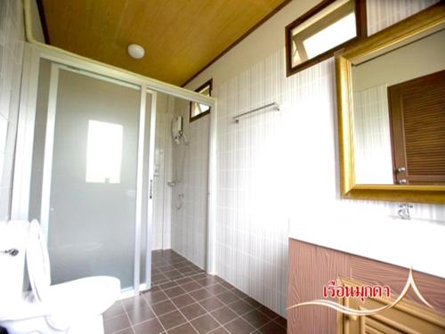 a bathroom with a toilet and a sink and a mirror at บ้านไร่คุณนาย in Ban Sap Bon
