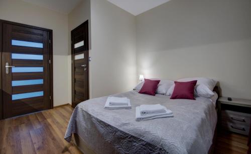 a bedroom with a bed with two towels on it at Willa Świderka in Kościelisko