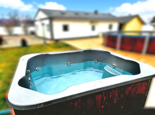 a bath tub in a yard with a house in the background at Zajazd Rest in Przemyśl