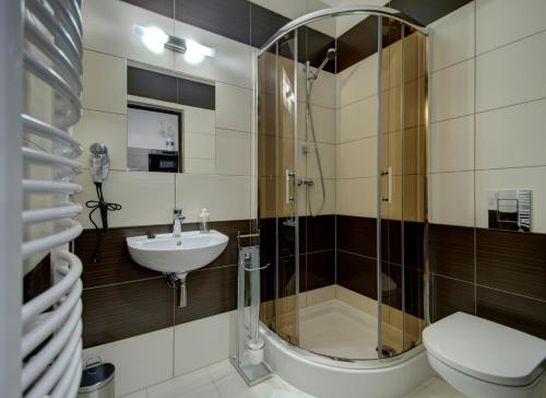a bathroom with a shower and a toilet and a sink at Willa Świderka in Kościelisko