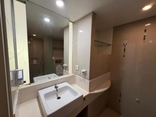 a bathroom with a sink and a large mirror at New Jimbaran Hotel in Ungasan
