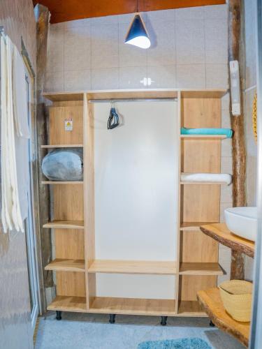 a shower in a bathroom with wooden shelves at Sea Eagle Oceanfront in Buyuni