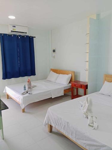a room with two beds and a blue curtain at The Soul Center in Batuan